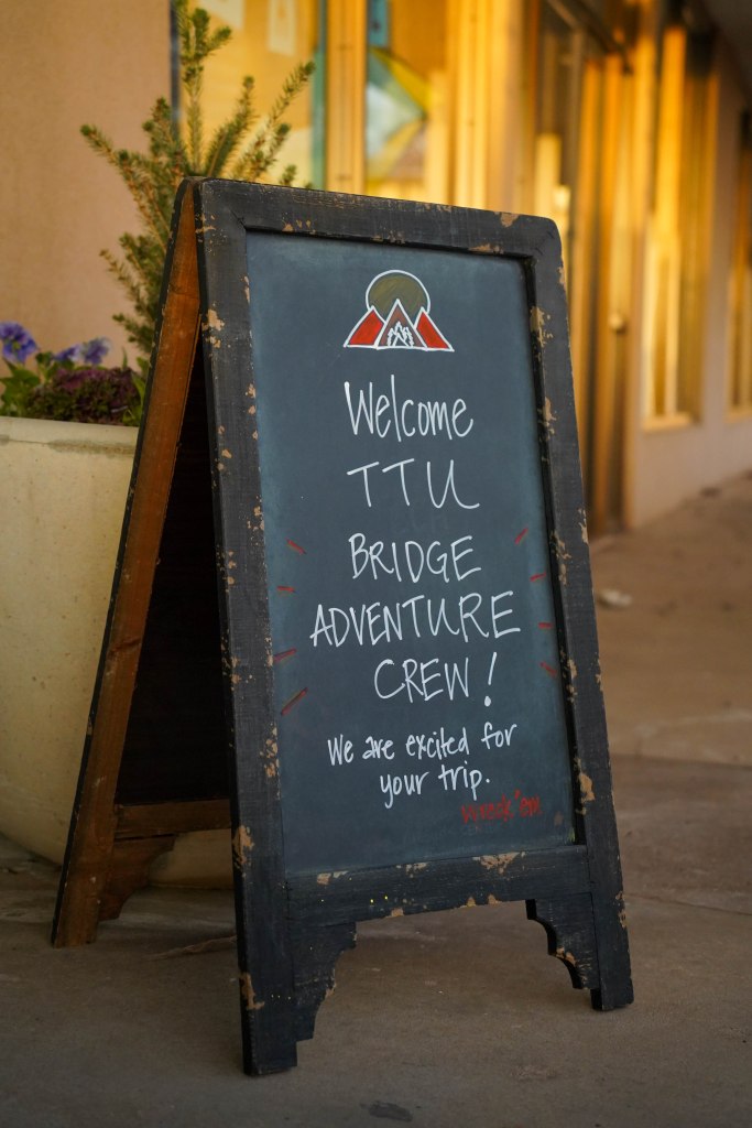 Welcome sign for TTU Bridge Adventure Crew outside a building.
