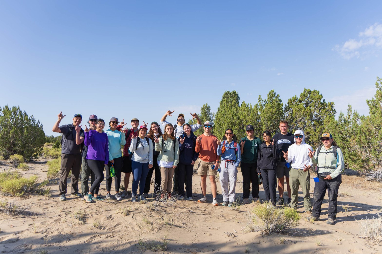 Members of the Bridge Adventure Program take a group photo in a sandy area in Utah.